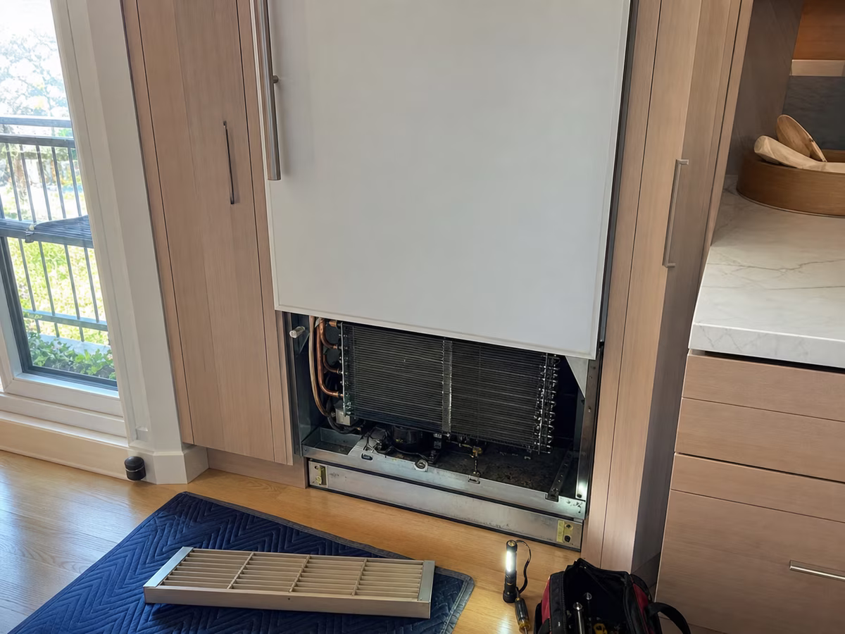 Built-in Sub-Zero refrigerator column in a Mill Valley kitchen with the lower grille removed for condenser access