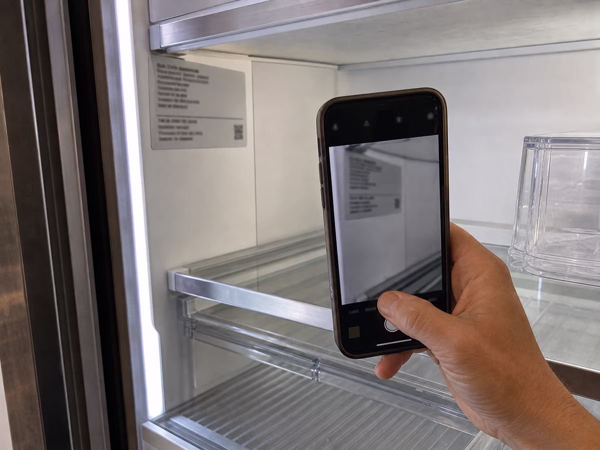 Phone camera close to a Sub-Zero model tag before booking a repair